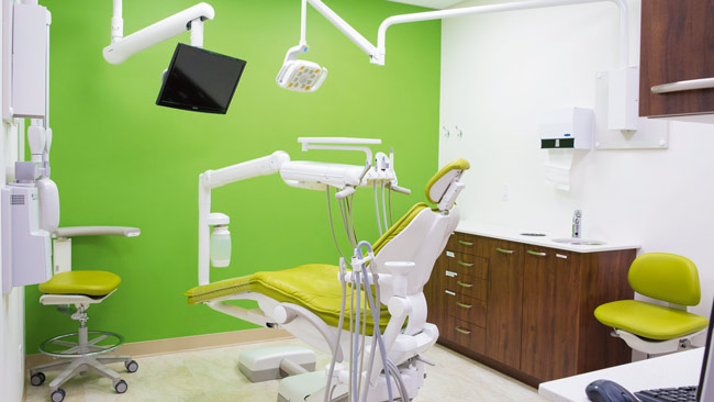 An exam room with a green accent wall